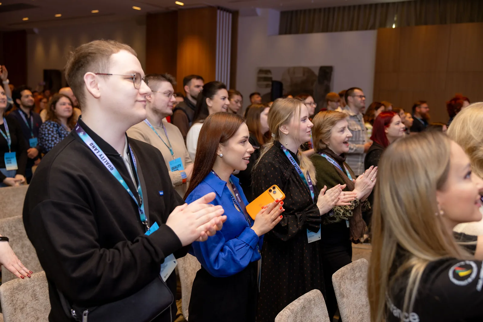 The Quality Land 2026 audience on its feet applauding, rows of seats filled to the back of the hall.